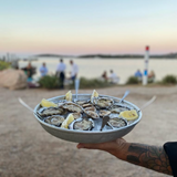 Austernverkostung bei Sonnenuntergang am Strand